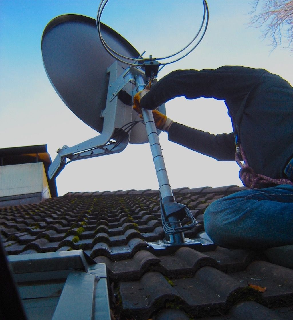 Satelliten-Monteur auf dem Dach